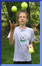 Anna juggling three tennis balls.