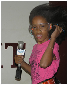 Taylor wearing goggles and holding a microphone.