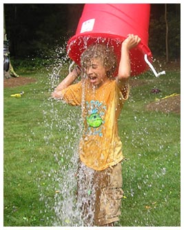 Khalil dumping a bucket of water on his head.