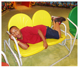 Khalil lying on a yellow bench in Studio G.