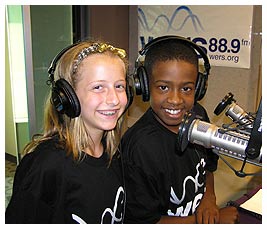 Madi and Mike in the recording studio wearing headphones.