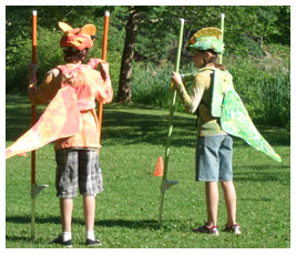 Two FETCHers stand on a race course and hold stilts.