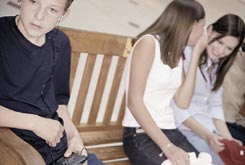 Girls whispering behind boy's back