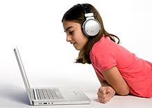 A kid listening to music on a computer
