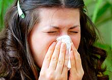 A girl sneezing into a tissue